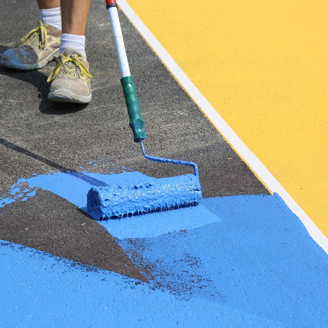 MAPECOAT TNS FAST being applied to a cycle track with a roller, showing smooth, colorful finish ideal for heavy foot traffic and outdoor surfaces