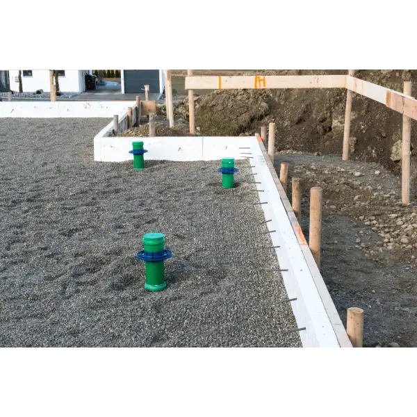 Green plumbing vent pipes above gravel with KG-FIX Hauff Wall Collar Pipe Sealing Flanges