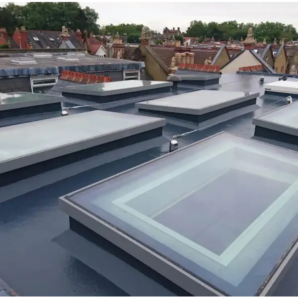 Multiple flat skylights installed on a roofing surface with Desmopol liquid coatings