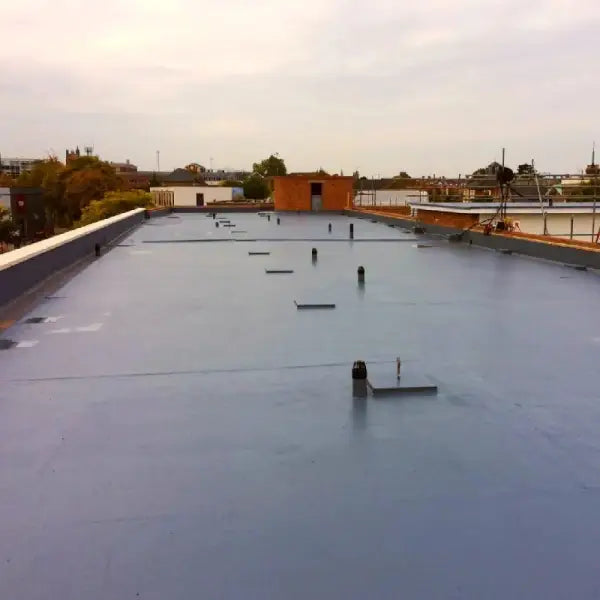 Flat commercial rooftop featuring gray rubber membrane from Desmopol liquid coatings