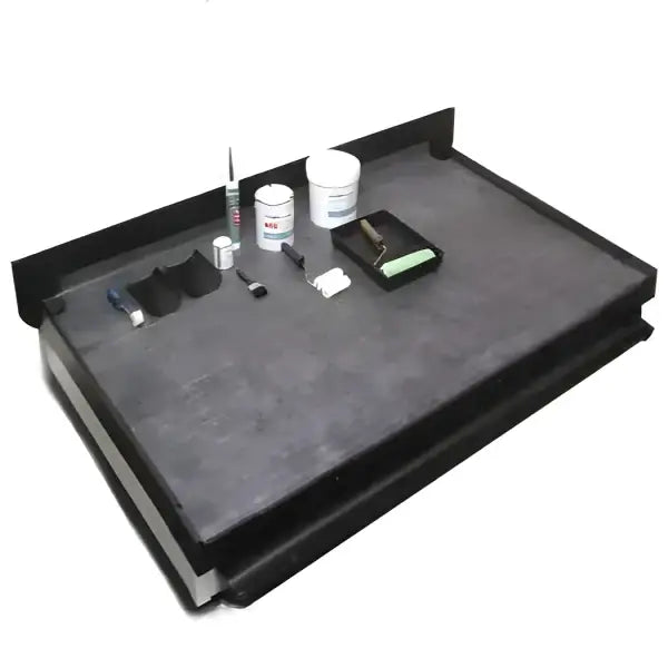 Dark rectangular tiered work surface with tools for Flat Rubber Roof Kits installation