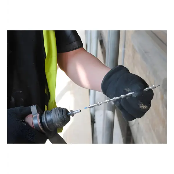 Worker inserting drill bit into drill for Helical 9mm CD Wall Tie Packs