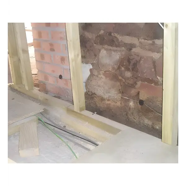 Wooden wall studs installed against a brick wall for Lectros Damp Proofing Anodes