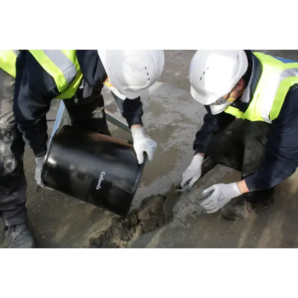 Construction workers in safety gear installing black pipe for Mixing Tools project