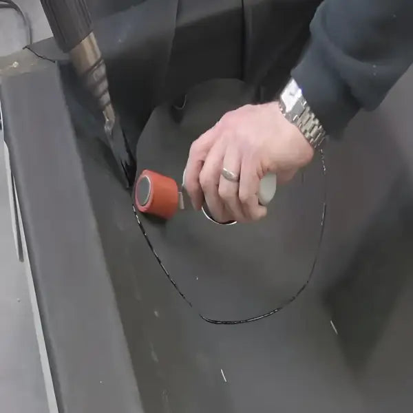 Person applying sealant with roller on Self Adhesive Drain Outlet for effective sealing