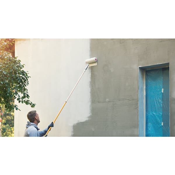 Man painting exterior wall with roller using SIRAMIGUARD MASONRY for optimal results