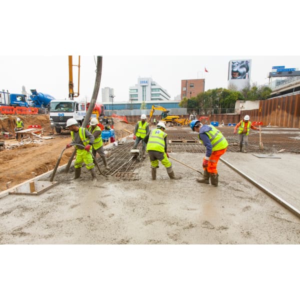 Construction workers pouring concrete while using TT Admix Concrete Waterproofing 4.1Kg