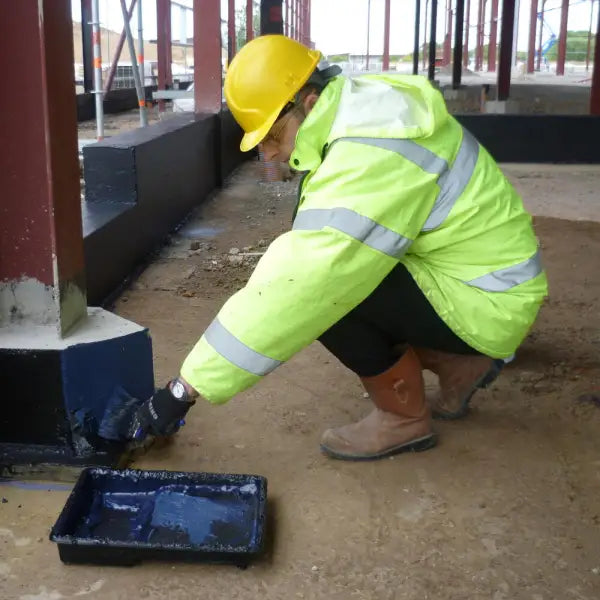 Construction worker applying Visqueen Liquid Gas Membrane to steel structure surface