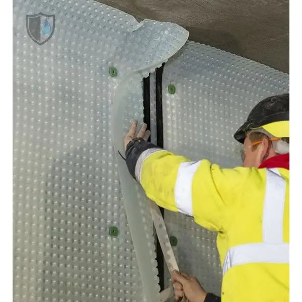 Worker in safety gear installing Wykamol Corner Strip Tape waterproofing membrane